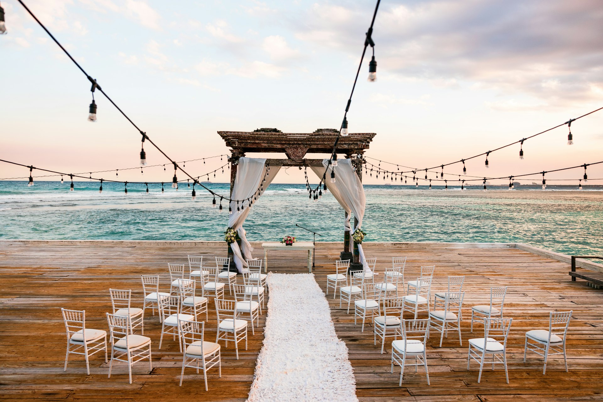 a wedding set up on a pier with white chairs